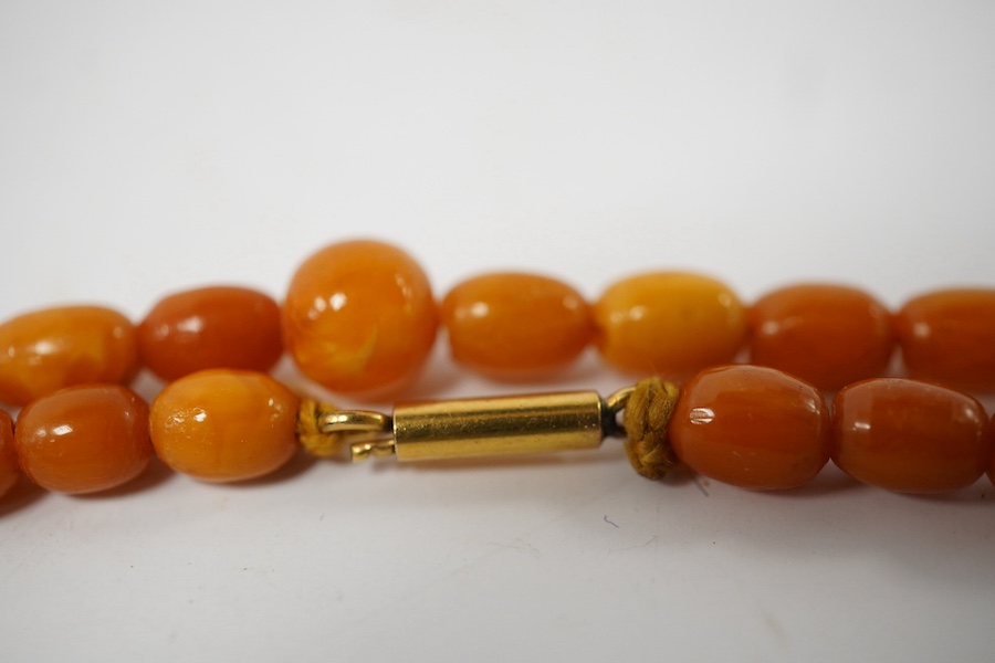 A single strand amber bead necklace, 72cm, gross weight 14 grams, together with a Victorian silver and malachite inset vinaigrette(a.f.) and a white metal and Scottish hardstone set bracelet(a.f.). Condition - poor to fa